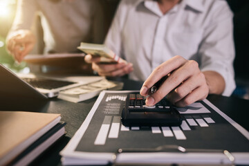 Business team working with calculator, business document and laptop computer notebook at home office in the morning.