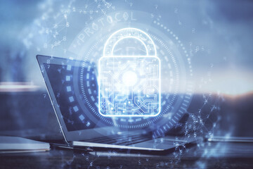 Double exposure of desktop with computer and lock icon hologram. Concept of data safety.