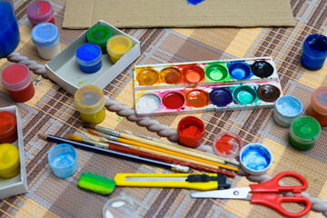 watercolor paints and paper closeup for drawing, artistic creation at home, workspace for make...