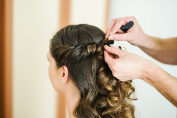 Fototapeta premium A WOMAN GETTING A HAIR DO BY A PROFFESIONAL HAIRDRESSER. CURLS MAKING