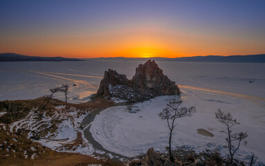 Landscape of Shamanka rock at sunset in frozen Lake Baikal, Siberia, Russia.