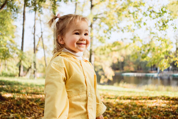 Caucasian child girl dressed in a jacket walks in the park