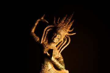 Close up of isolated illuminated balinese dancing bronze sculpture