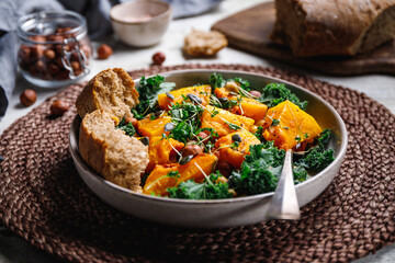 Season salad with grilled pumpkin, kale, chickpea, pepitas and nuts. Autumn vegetarian healthy recipe.