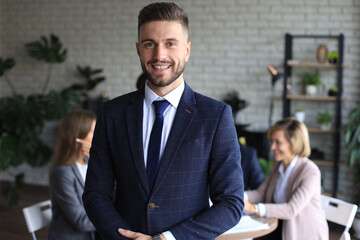 Businessman with colleagues in the background in office.