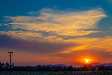 beautiful orange cloudy sunset at the fields 