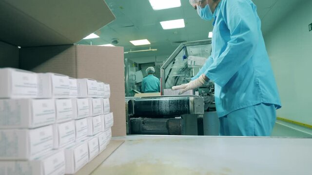 Pharmacologist putting medicines in a box