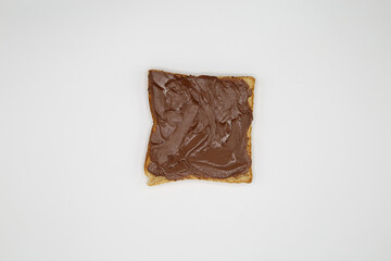 Top down view on isolated slice toast bread with shiny brown nut nougat creme spread on white blank background