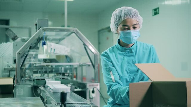 Female health worker packing medicines. Drugs production, pharmacist working, pharmaceutical manufacturing, pharmaceutical industry concept.