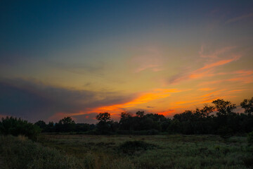 Fototapeta na wymiar beautiful orange cloudy sunset at the fields 
