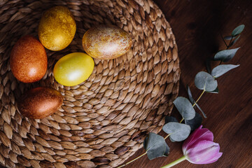 golden eggs on wicker natural background, easter eggs, unusual stylish food design 