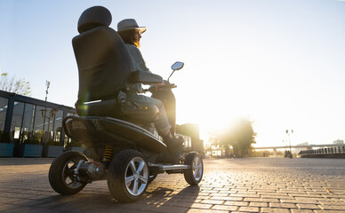 Woman tourist riding a four wheel mobility electric scooter on a city street.  © scharfsinn86
