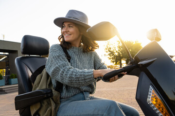 Woman tourist riding a four wheel mobility electric scooter on a city street.  © scharfsinn86