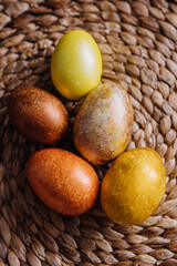 golden eggs on wicker natural background, easter eggs, unusual stylish food design 