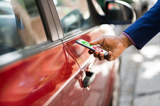 African Man Unlocking Car Using Smartphone