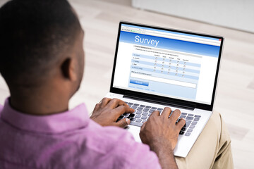 Man Giving Online Survey On Laptop