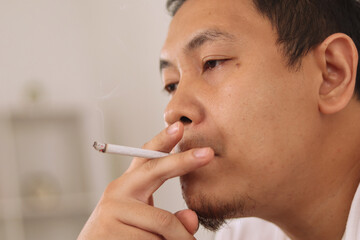 Nervous anxious Asian man smoking cigarette, depression or panic attack nicotine addiction