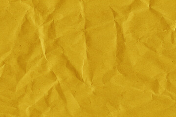 Yellow vintage and old looking crumpled paper background. Retro cardboard texture. Grunge paper for drawing. Ancient book page. Present wrapping.