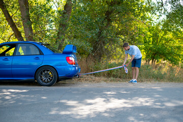 man holding a towing rope and install it on the car hook, the auto accident and problem with engine