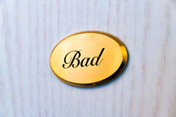 A golden door sign with the inscription "Bad" in German (translated: bathroom)