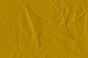 Yellow vintage and old looking crumpled paper background. Retro cardboard texture. Grunge paper for drawing. Ancient book page. Present wrapping.