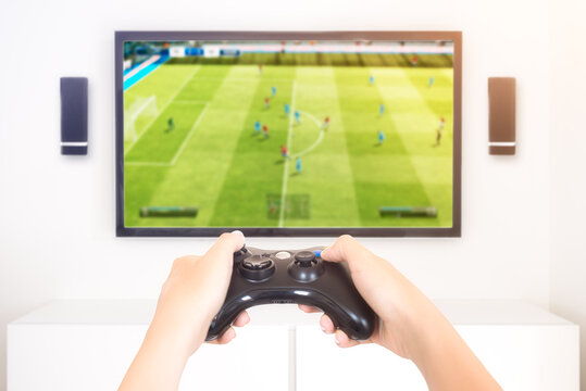 Player playing console soccer game videogame holding gamepad - high key image
