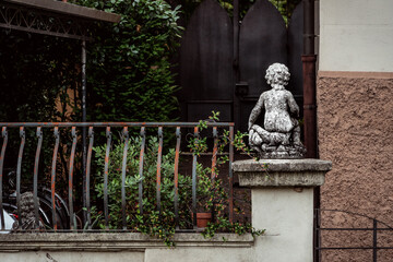 stone statue of angel from behind in italian garden