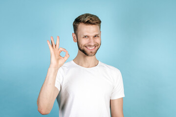 Young adult guy making okay sign and smiling nice