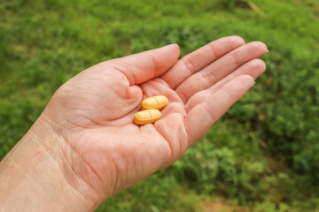 Woman with a handfull of pills, vitamins, or drugs.