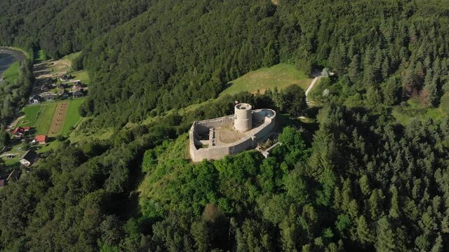 Aerial view of medieval castle in summer on top of mountain in middle of forest. Beskid Mountains, village Rytro, Poland.