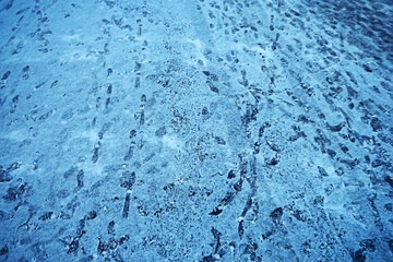 Fototapeta na wymiar tracks asphalt snow, ice, people’s tracks from shoes on snow, snow removal weather