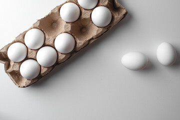 Many fresh raw chicken white eggs in cartons without two eggs as background, top view. Place for text