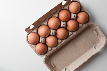 Many fresh raw chicken brown eggs in cartons as background, top view. Place for text