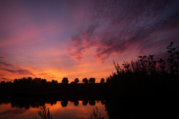 Obraz premium A breathtaking colorful dawn which gets reflected in the water, with a beatiful sky.