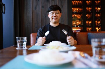 Man eating rice enjoying a meal in restaurant. man having dinner