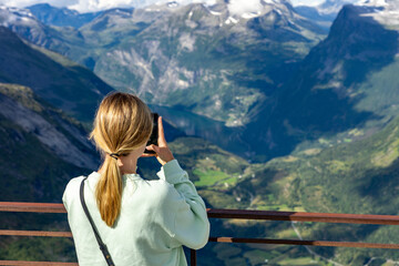 Urlaub in Süd-Norwegen: Frau / Touristin schaut glücklich vom Aussichtspunkt Dalsnibba ins Tal...