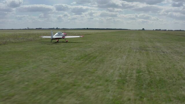 Small single-engine plane travels on a green field, makes a run before takeoff, summer, green grass, the concept of small aircraft. 
The plane takes off