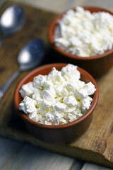 Selective focus. Fresh granular cottage cheese in bowls. Rustic style.