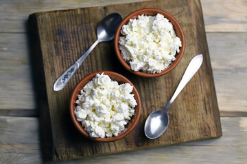 Selective focus. Fresh granular cottage cheese in bowls. Rustic style.