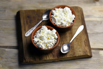 Selective focus. Fresh granular cottage cheese in bowls. Rustic style.