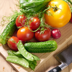 juicy farm vegetables on a wooden board, tomato, cucumber, greens, green peas