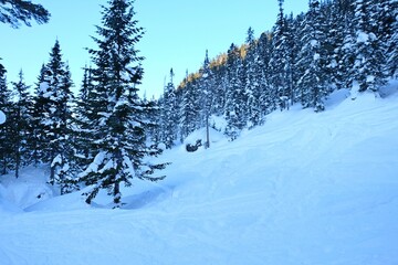 Winter mountain landscape at Baikal. Khamar-Daban ridge. Snow-capped peaks, chalets in the mountains. Winter forest.