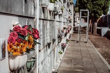 plastic flower bouquet on urne wall at cemetery