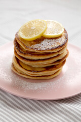 Homemade Lemon Ricotta Pancakes on a pink plate, low angle view. Close-up.