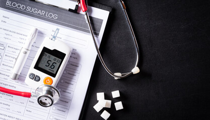 Stethoscope with patient's blood sugar control chart, diabetic measurement  set and sugar on blackbord background. World Diabetes day, 14 November.