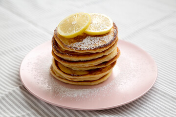 Homemade Lemon Ricotta Pancakes on a pink plate, side view. Close-up.