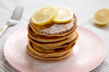 Homemade Lemon Ricotta Pancakes on a pink plate, side view. Close-up.
