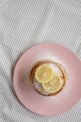 Homemade Lemon Ricotta Pancakes on a pink plate, top view. Flat lay, overhead, from above. Copy space.