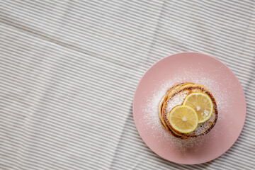 Homemade Lemon Ricotta Pancakes on a pink plate, top view. Flat lay, overhead, from above. Copy space.