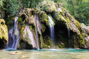 La cascade des Tufs, chute d'eau de la Cuisance, remarquable pour ses massifs de tuf, située dans la commune des Planches-près-Arbois dans le Jura, en Franche-Comté - obrazy, fototapety, plakaty